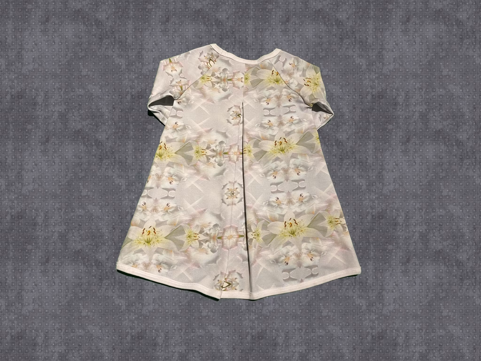Klänning med veck bak. Gråvit med vita blommor