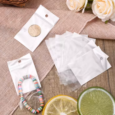 Cellofanpåsar med vit pärlfilm hål och limremsa 10x5cm 50st