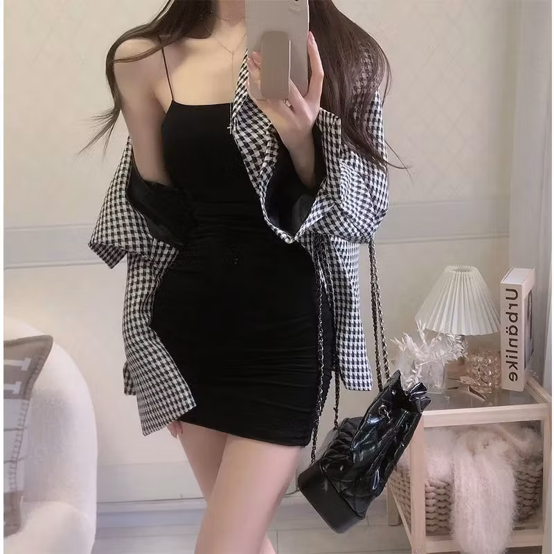 Black tight mini dress with spaghetti straps styled with a black and white checkered jacket and black shoulder bag