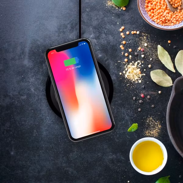 Minibatt UltraSLIM trådlös laddare laddar iPhone på svart bord