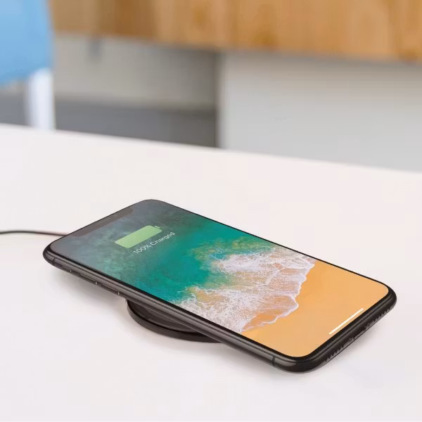 Minibatt UltraSLIM trådlös laddare laddar iPHone på bord, från sidan