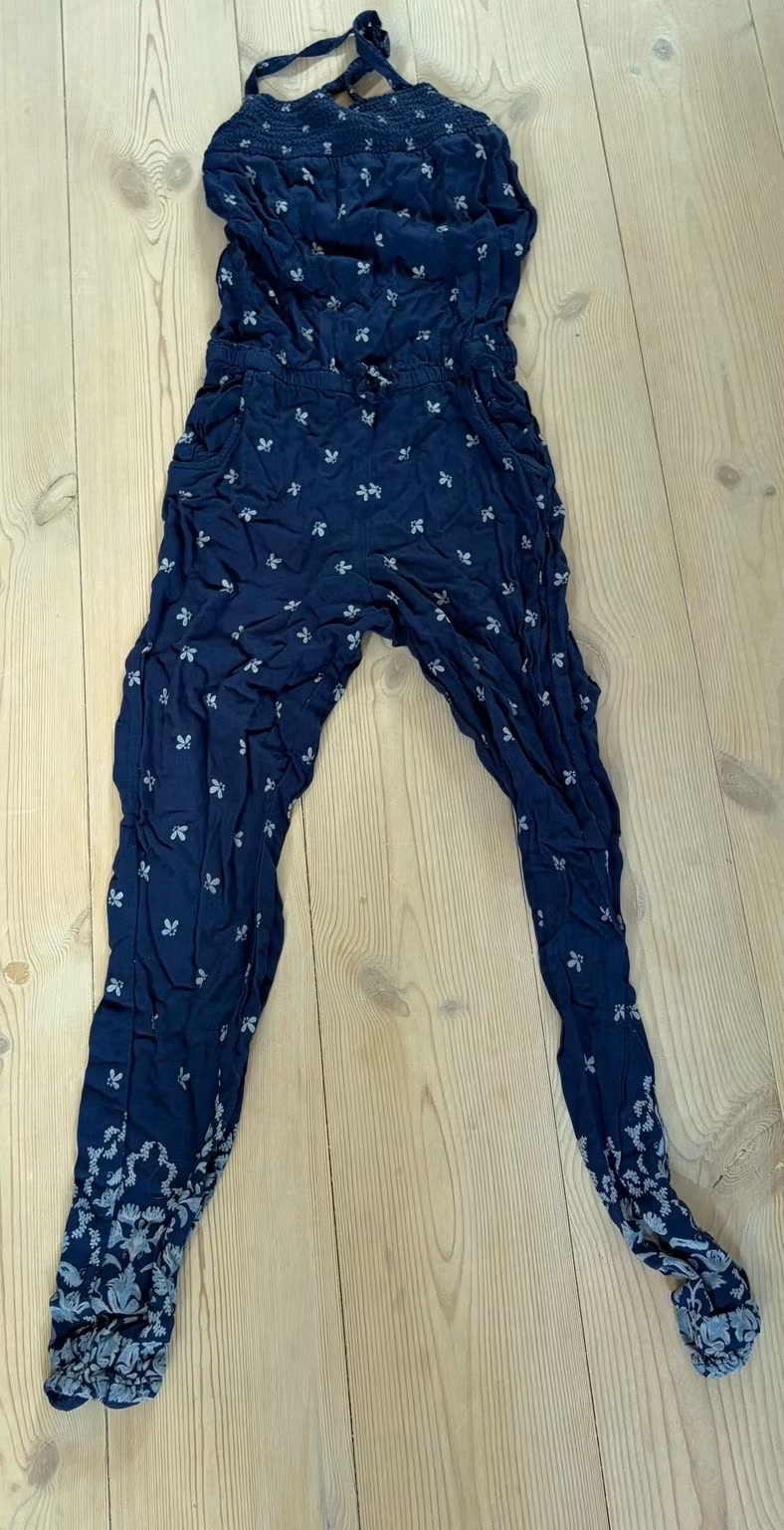 Forside af mørkeblå H&M-buksedragt med blomster, str. 128