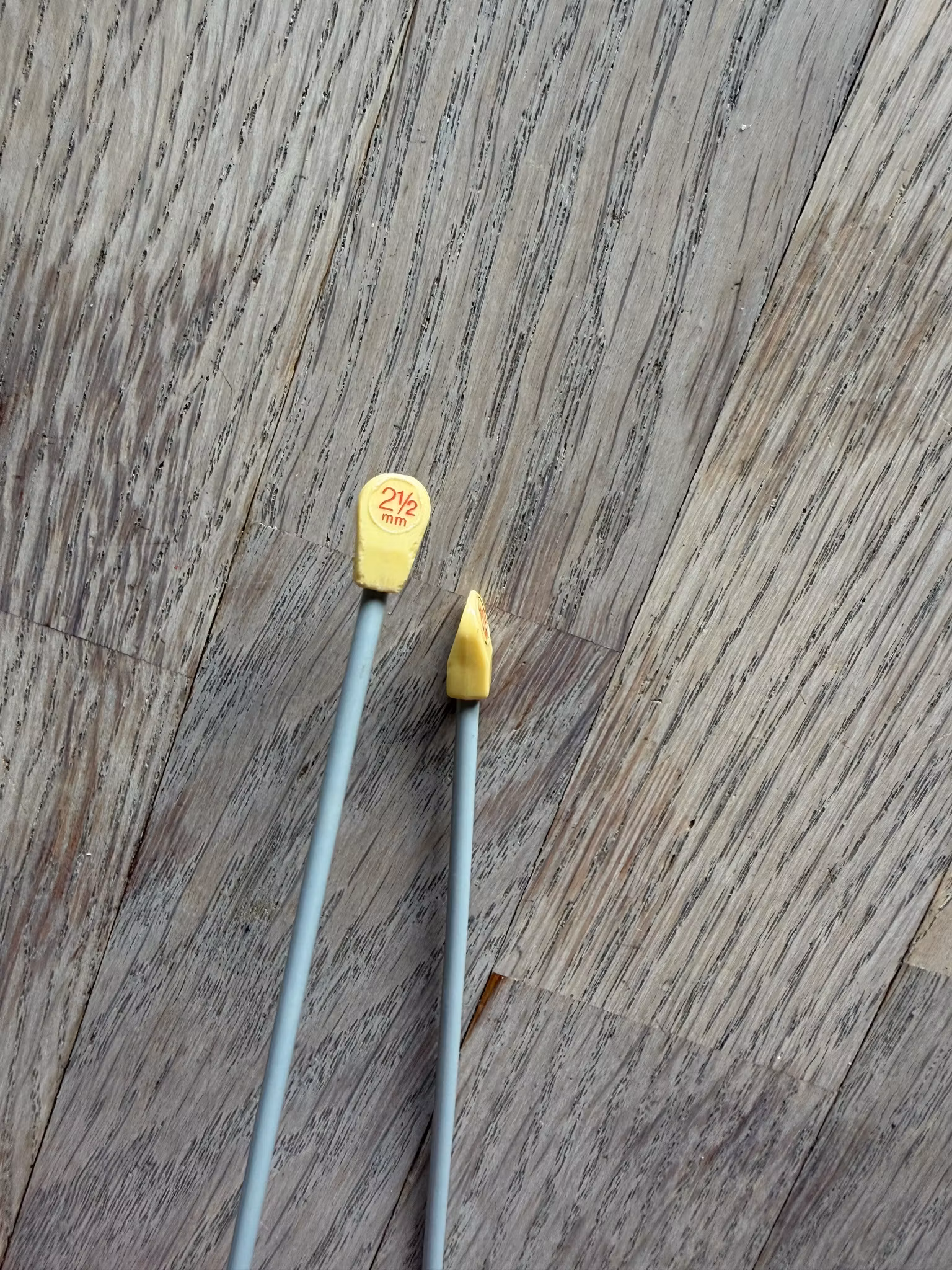2 1/2 mm jumperstrikkepinde i metal med gule plastikstoppere