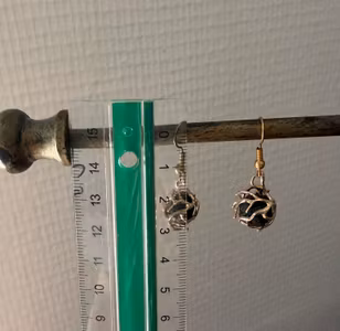 Små guldfarvede øreringe med sorte kuglevedhæng