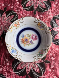 Blomsterdekoreret porcelænsskål med blå og guldfarvet kant