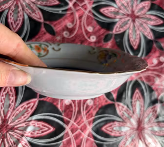 Blomsterdekoreret porcelænsskål med blå og guldfarvet kant