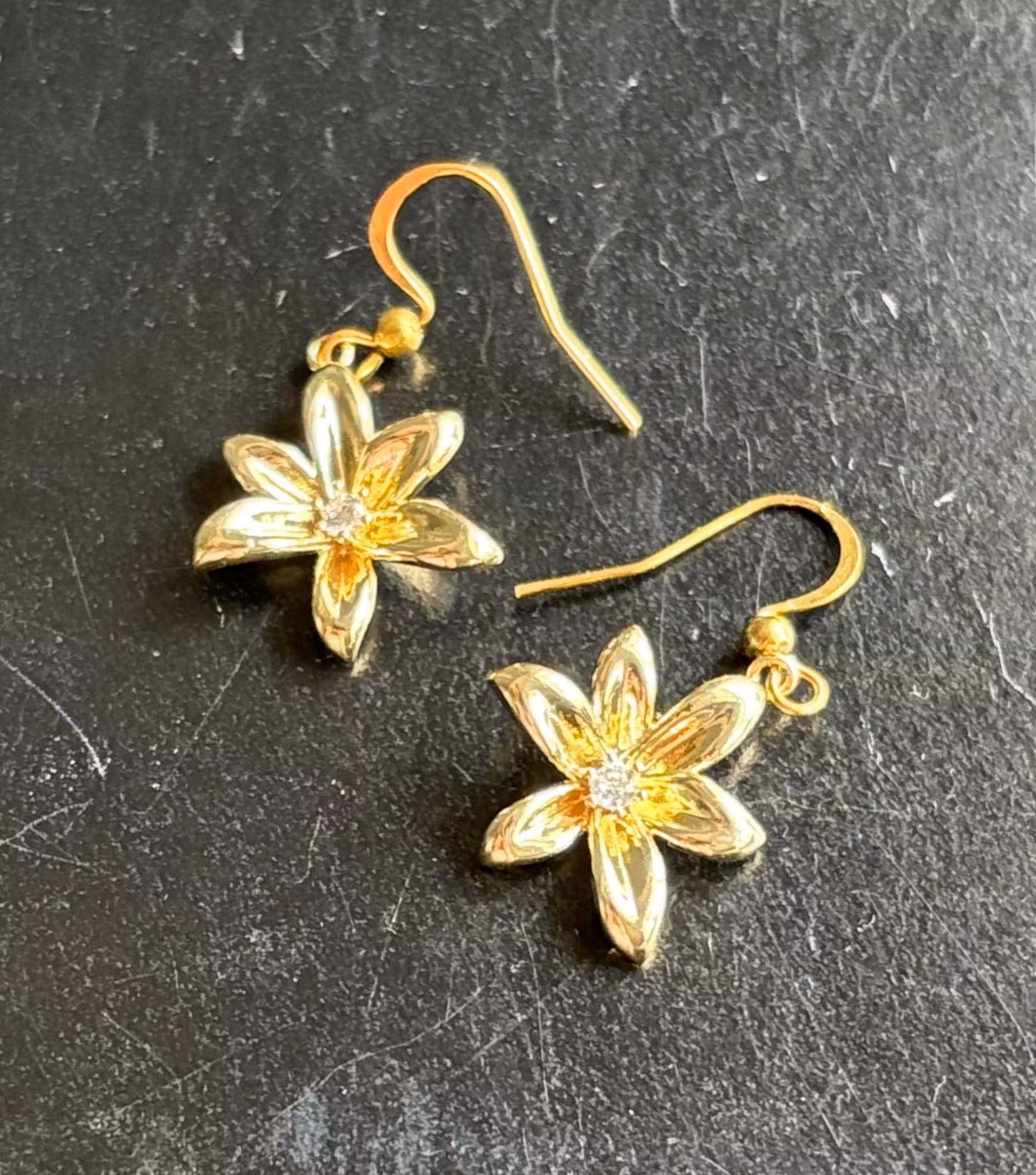 Øreringe med gyldne seksbladede blomster og klare sten – 1 par