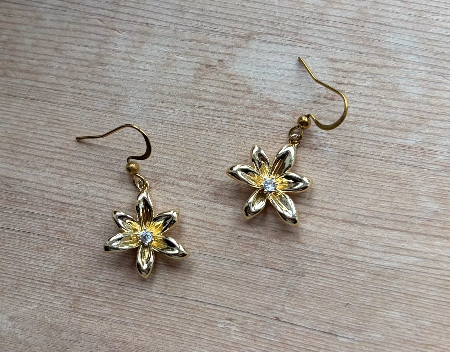 Øreringe med gyldne seksbladede blomster og klare sten – 1 par