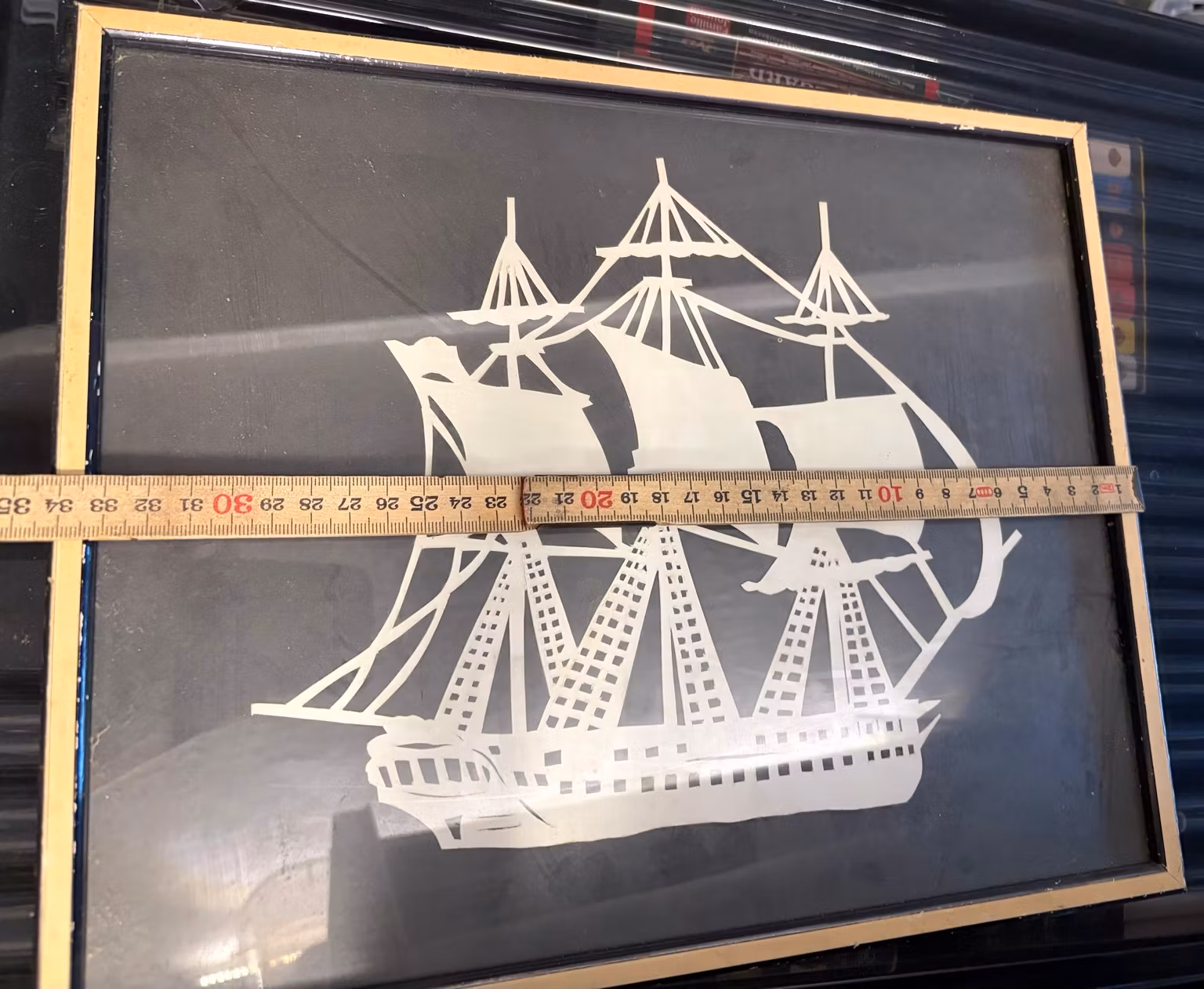 Billede med sejlskib – hvidt papirklip i guldfarvet ramme, ca. 34 × 29 cm