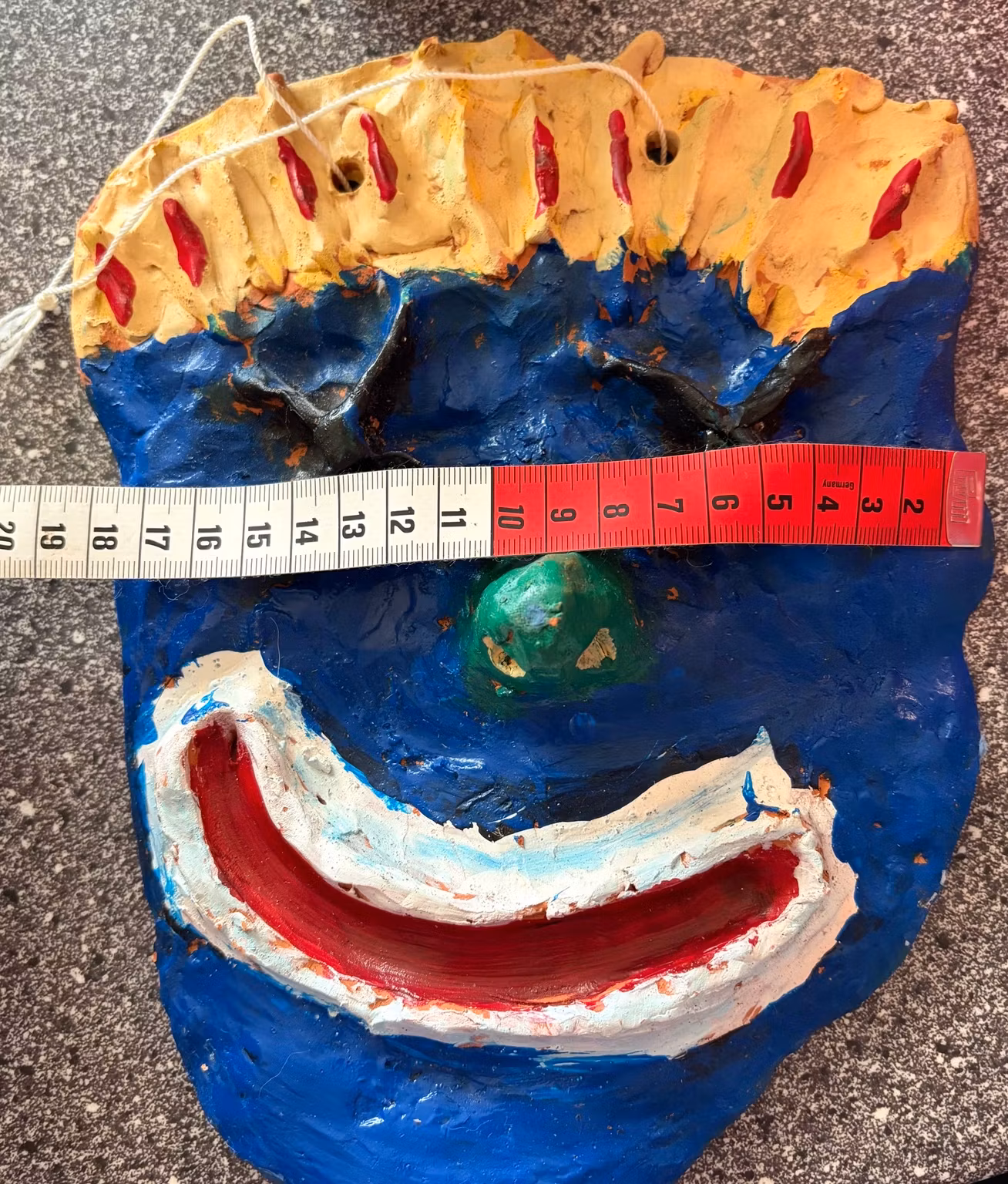 Vægmaske med smil – håndlavet, blå og gul, ca. 25 × 18 cm