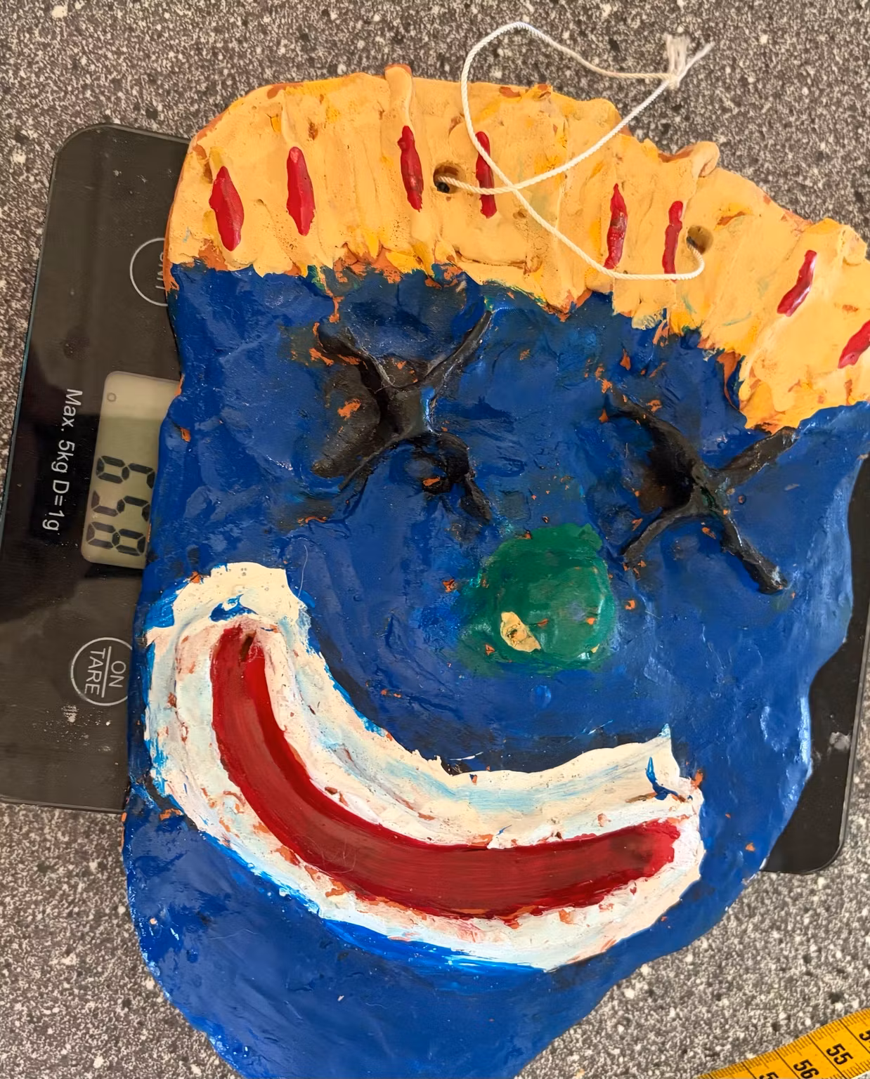 Vægmaske med smil – håndlavet, blå og gul, ca. 25 × 18 cm