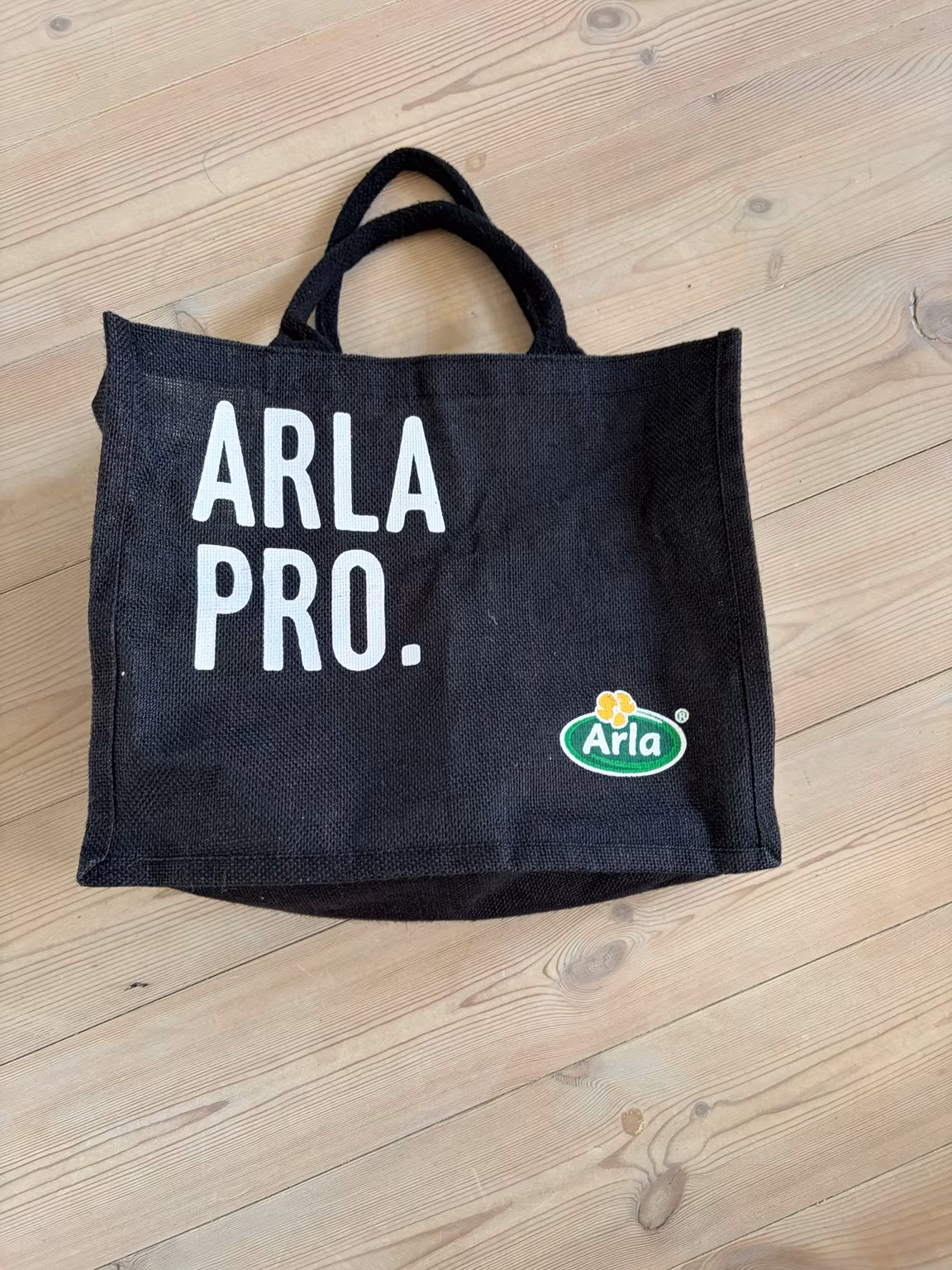 Indkøbstaske Arla Pro – sort med korte hanke, ca. 35 × 30 cm