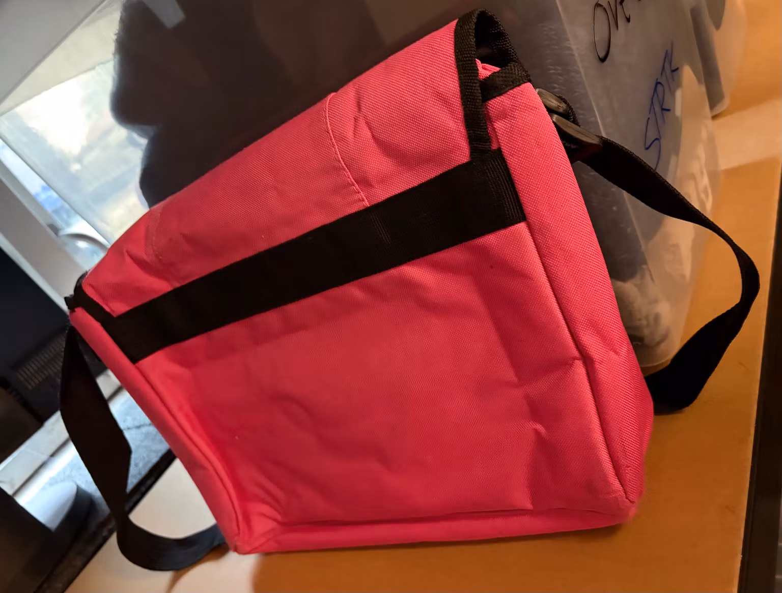 Oster-taskens bagside med sort skulderrem