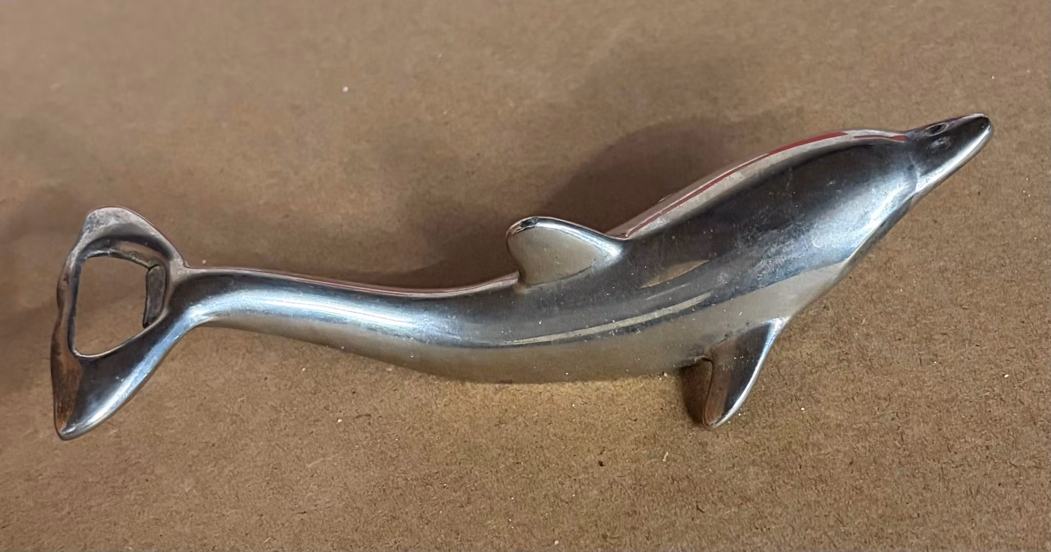 Originalfoto – Oplukker formet som delfin – sølvfarvet metal, ca. 17 cm