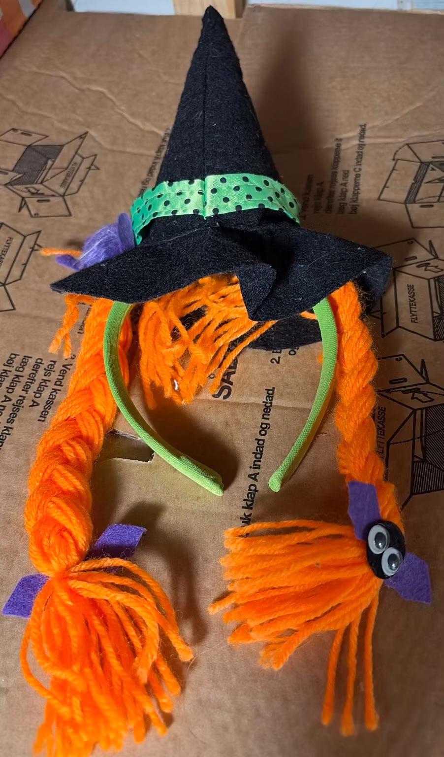 Hårbøjle med sort heksehat, orange fletninger og grøn bøjle