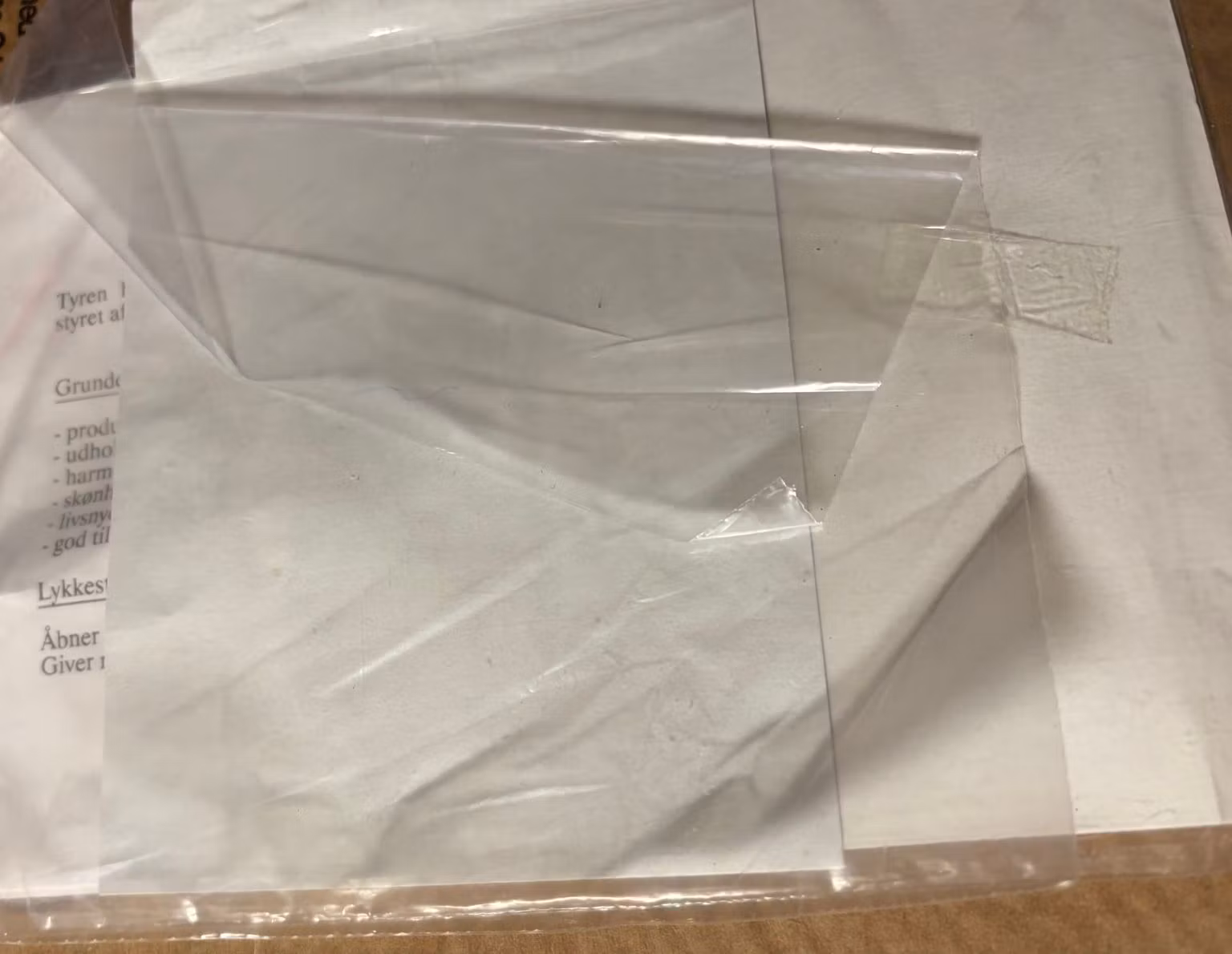 Tyren-kortets bagside med kuvert og plastpose