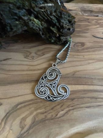 Halsband med valknut, månskära och triskile.