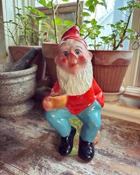 Tomte - sittande som kan hålla i ett ljus