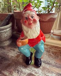 Tomte - sittande som kan hålla i ett ljus
