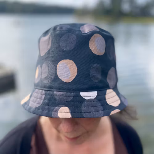 en "sassy n swag"-hatt med det smalare brättet i mönstret Chestnutty, med kastanjer på svart