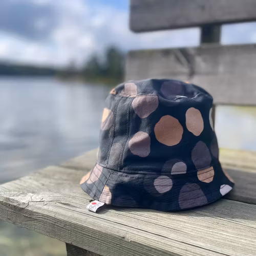 en "sassy n swag"-hatt med det smalare brättet i mönstret Chestnutty, med kastanjer på svart