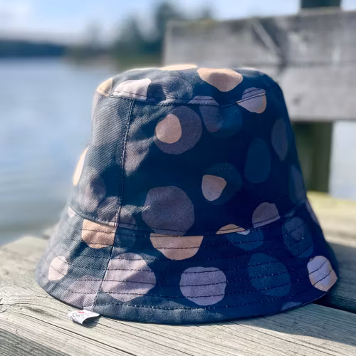 en "sassy n swag"-hatt med det bredaste brättet i mönstret Chestnutty, med kastanjer på svart
