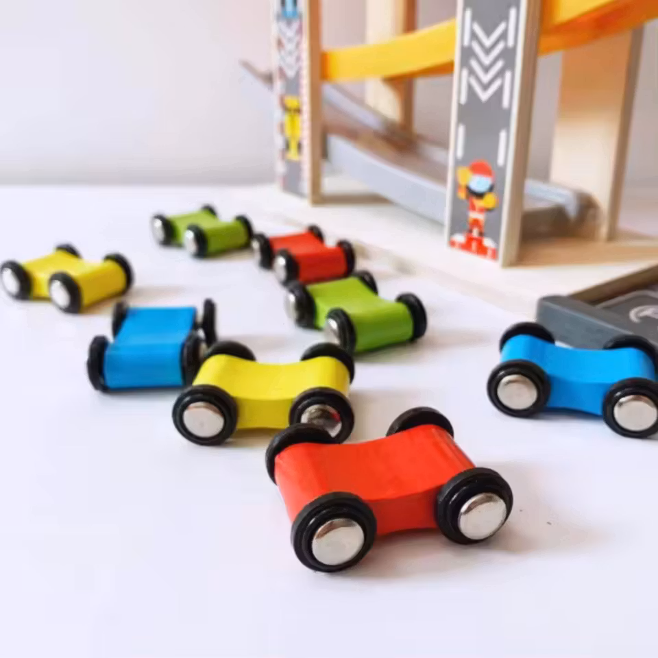 Bilbana i trä och plast med fyra små färgglada träbilar – perfekt för barn från 3 år.