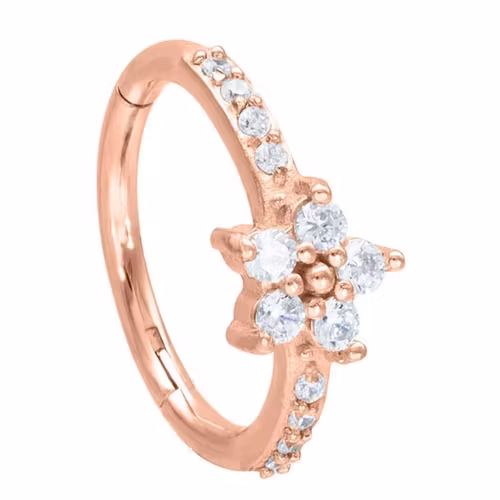 Vacker rosefärgad ring med vita stenar och en blomma, olika storlek