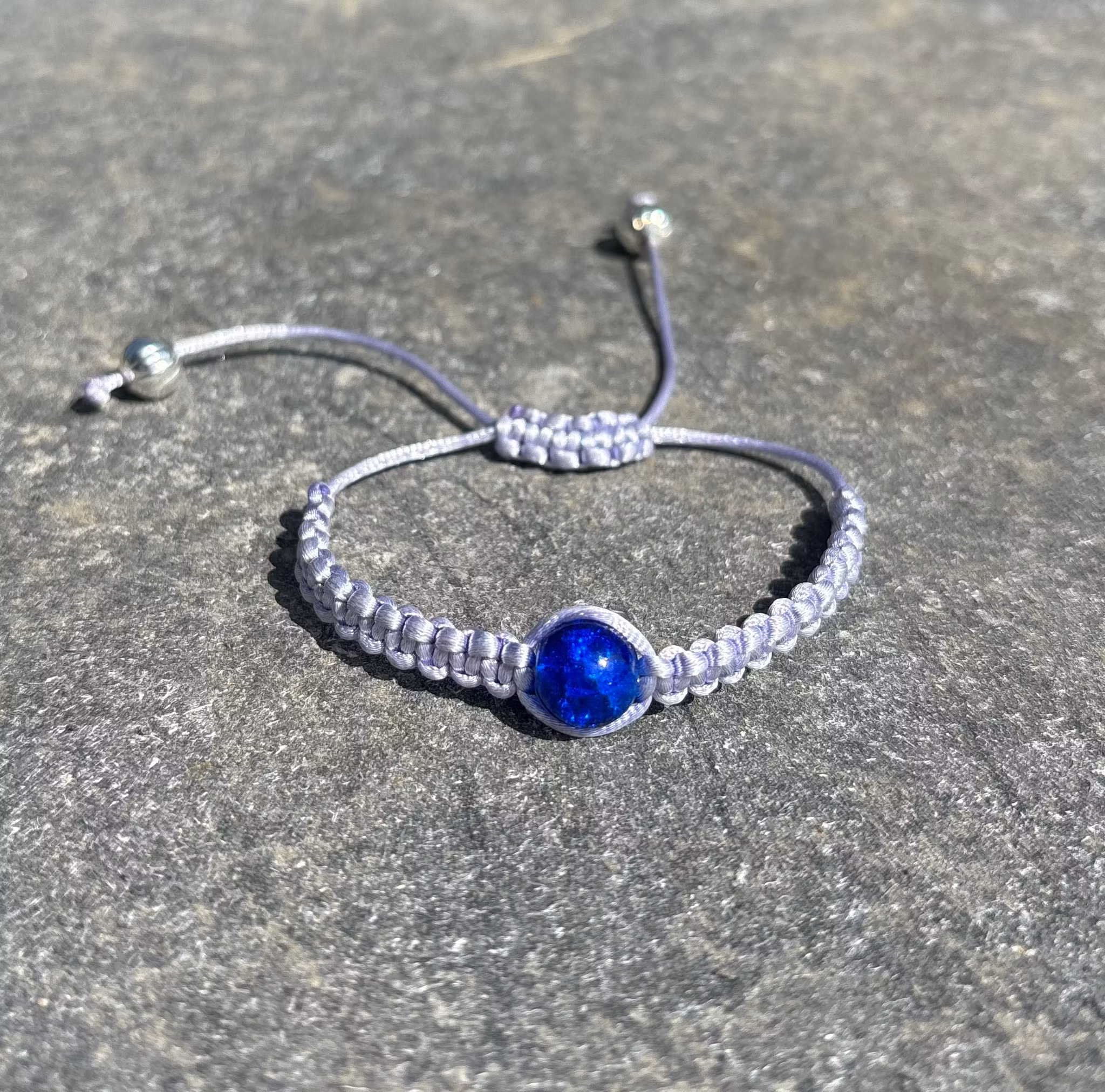 Blått makrame armband med en blå krackelerad glaspärla