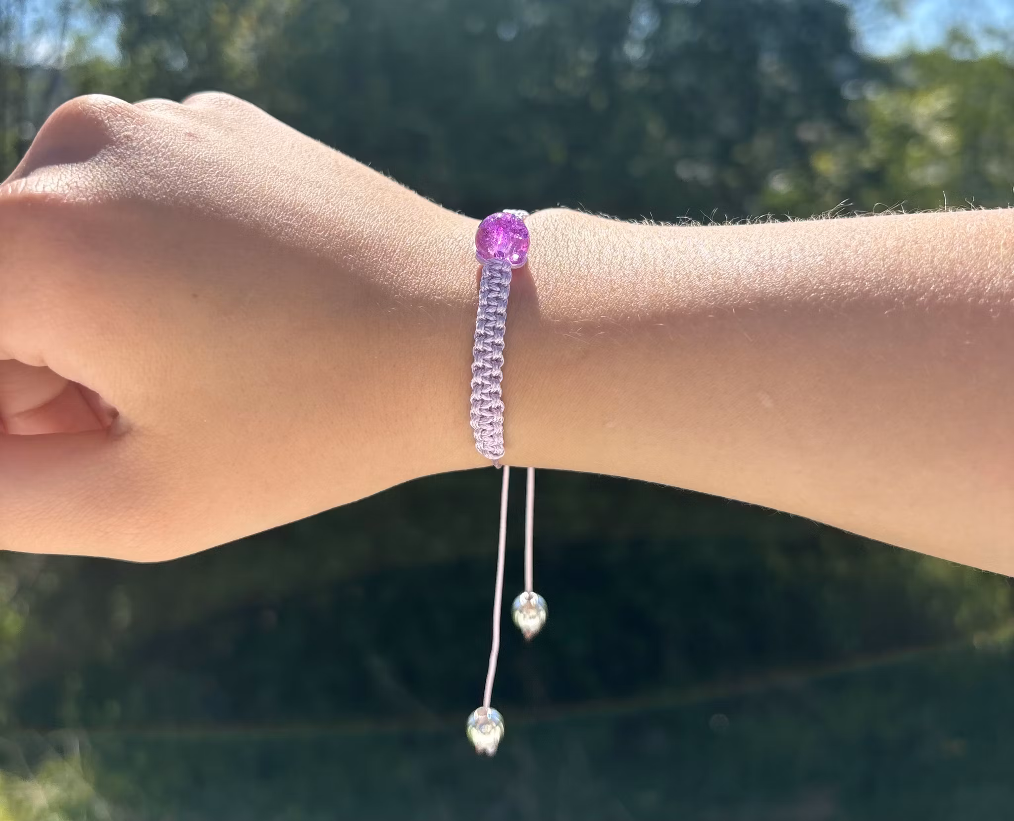 Lila makrame armband med en krackelerad glaspärla