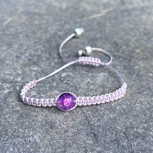 Lila makrame armband med en krackelerad glaspärla