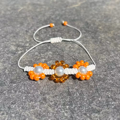 Orange makrame armband med blommor