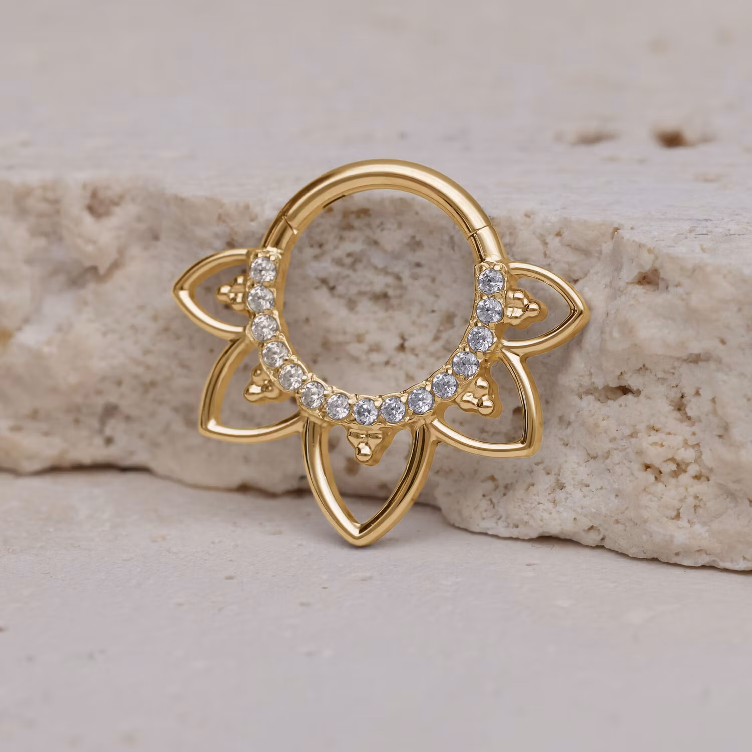Clickerring i guldig färg med vit strass och blomliknande detaljer 1,2x8 mm