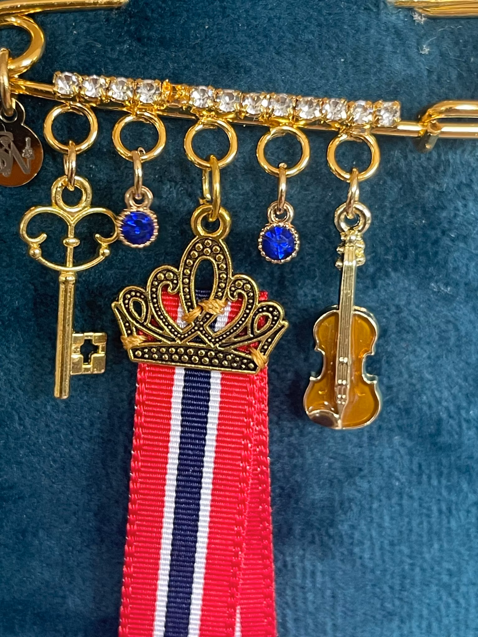 17. mai nål med krone og sløyfe – brosje til bunad med stabbursnøkkel, fiolin og blå krystaller