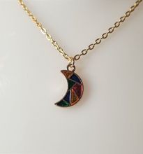 Guldfärgat halsband med en månformad berlock / charm