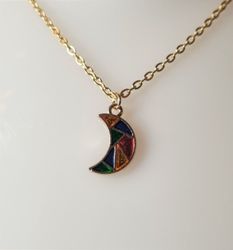 Guldfärgat halsband med en månformad berlock / charm