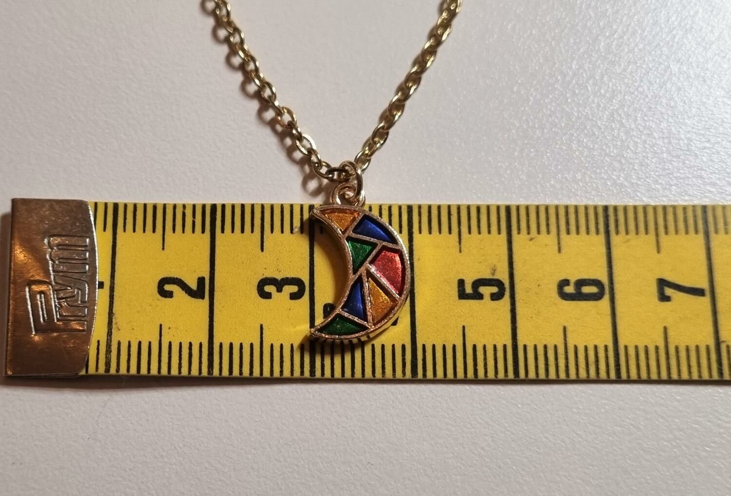 Guldfärgat halsband med en månformad berlock / charm