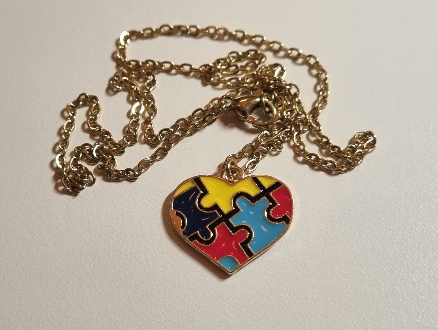 Guldfärgat halsband med en hjärtformad pusselbit, berlock / charm