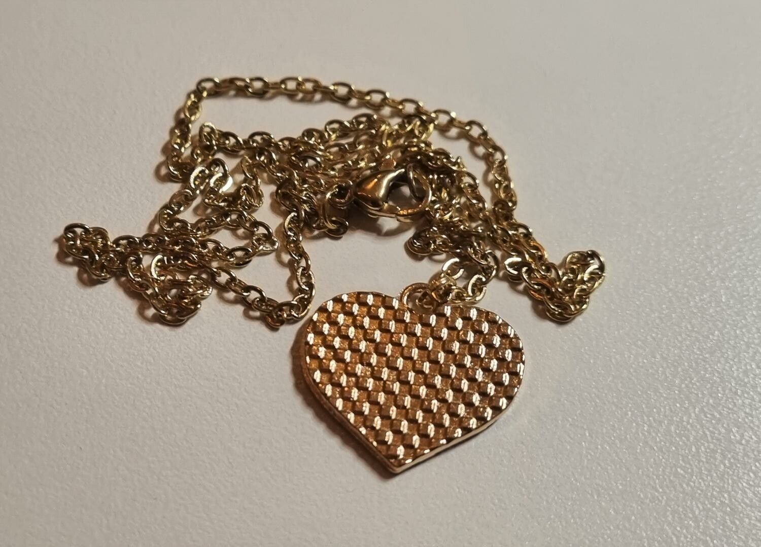 Guldfärgat halsband med en hjärtformad pusselbit, berlock / charm