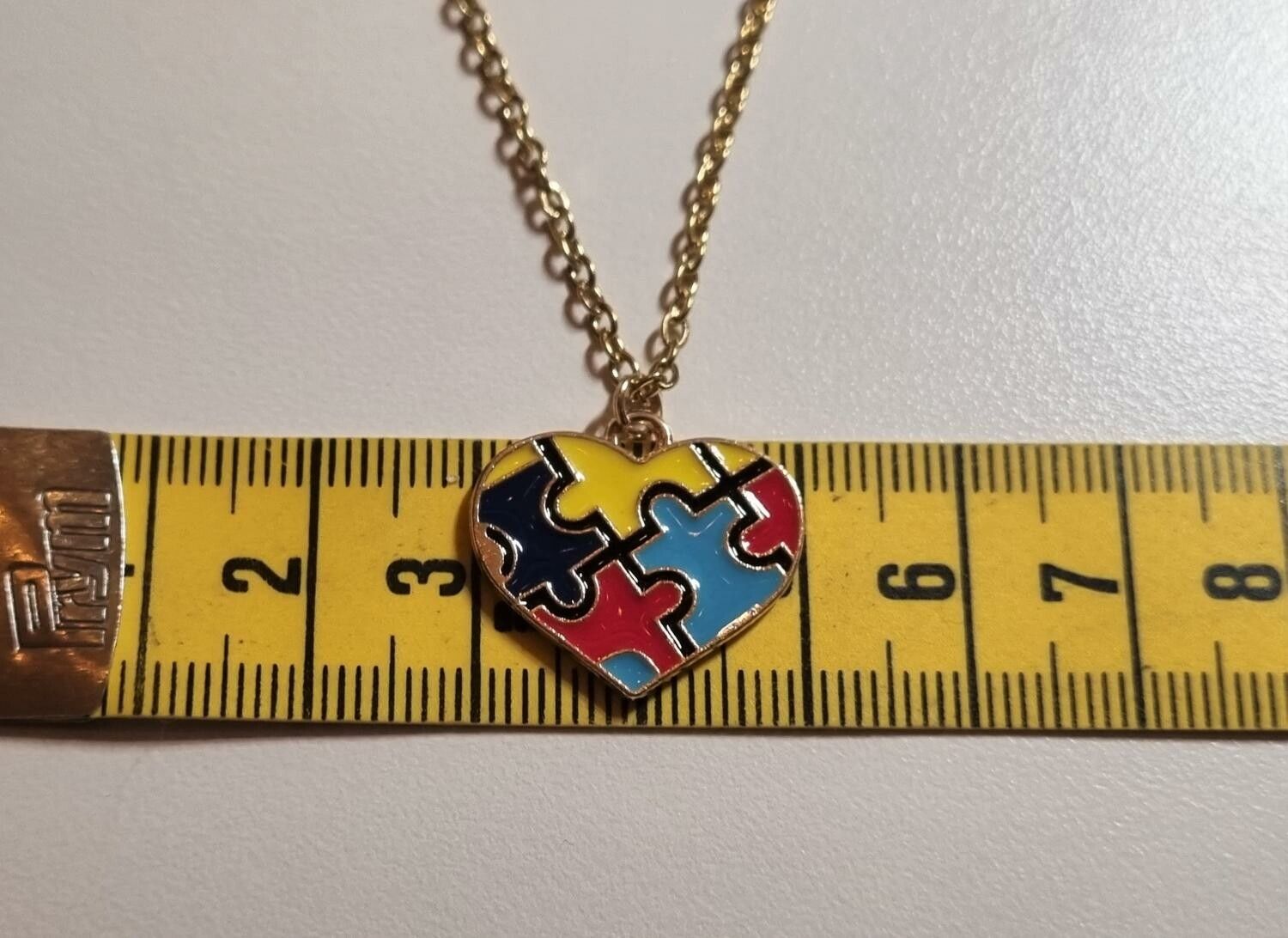 Guldfärgat halsband med en hjärtformad pusselbit, berlock / charm