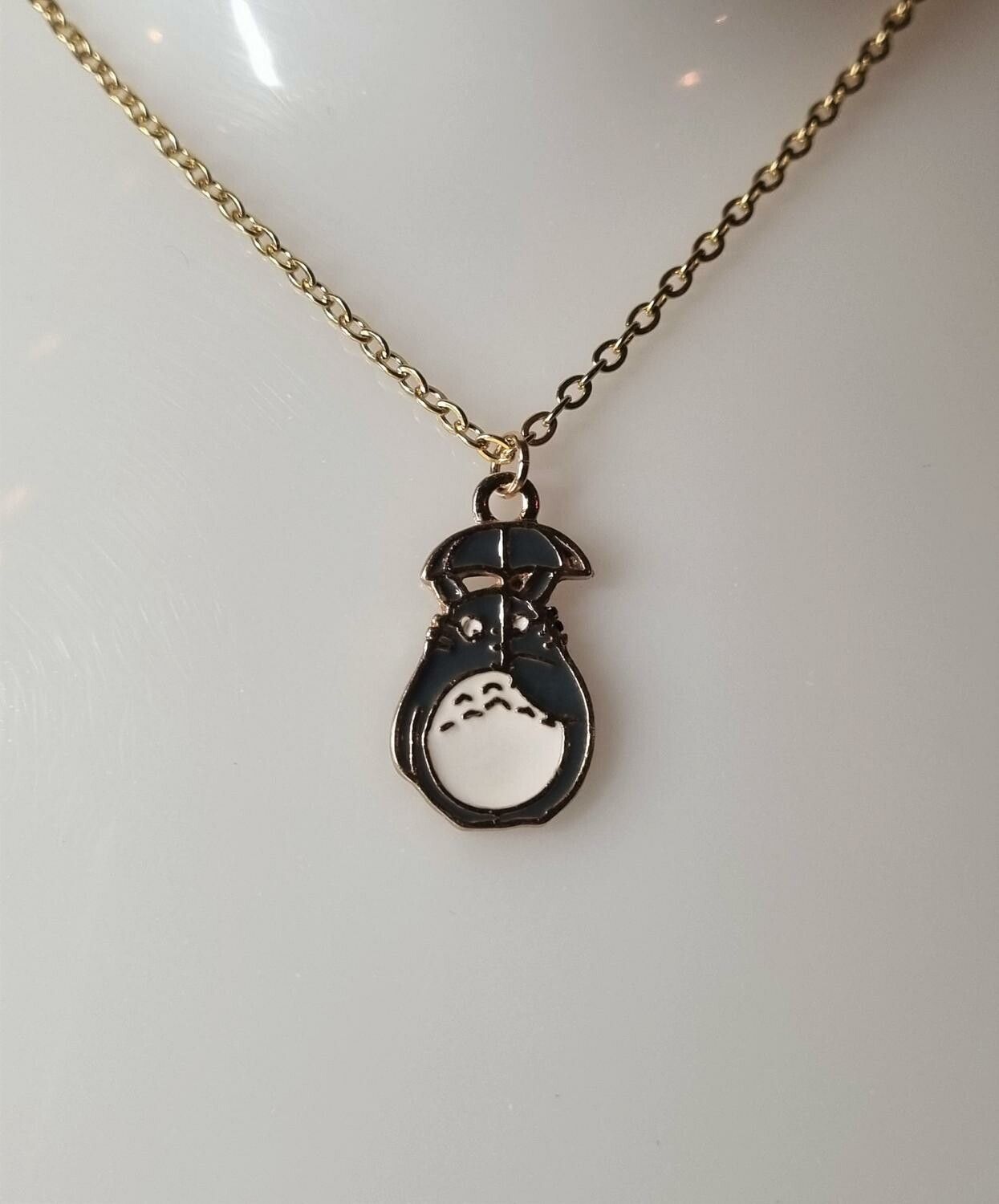 Guldfärgat halsband med en katt under ett paraply, berlock / charm