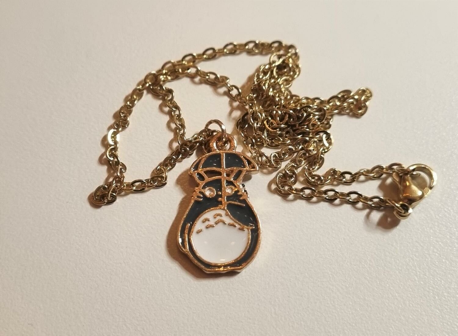 Guldfärgat halsband med en katt under ett paraply, berlock / charm