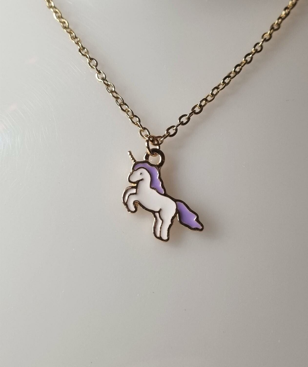Guldfärgat halsband med en lila enhörning, berlock / charm