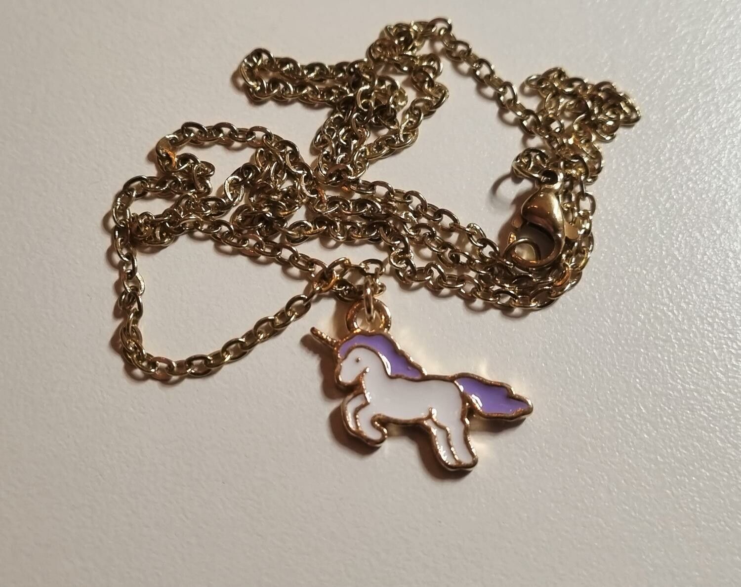 Guldfärgat halsband med en lila enhörning, berlock / charm