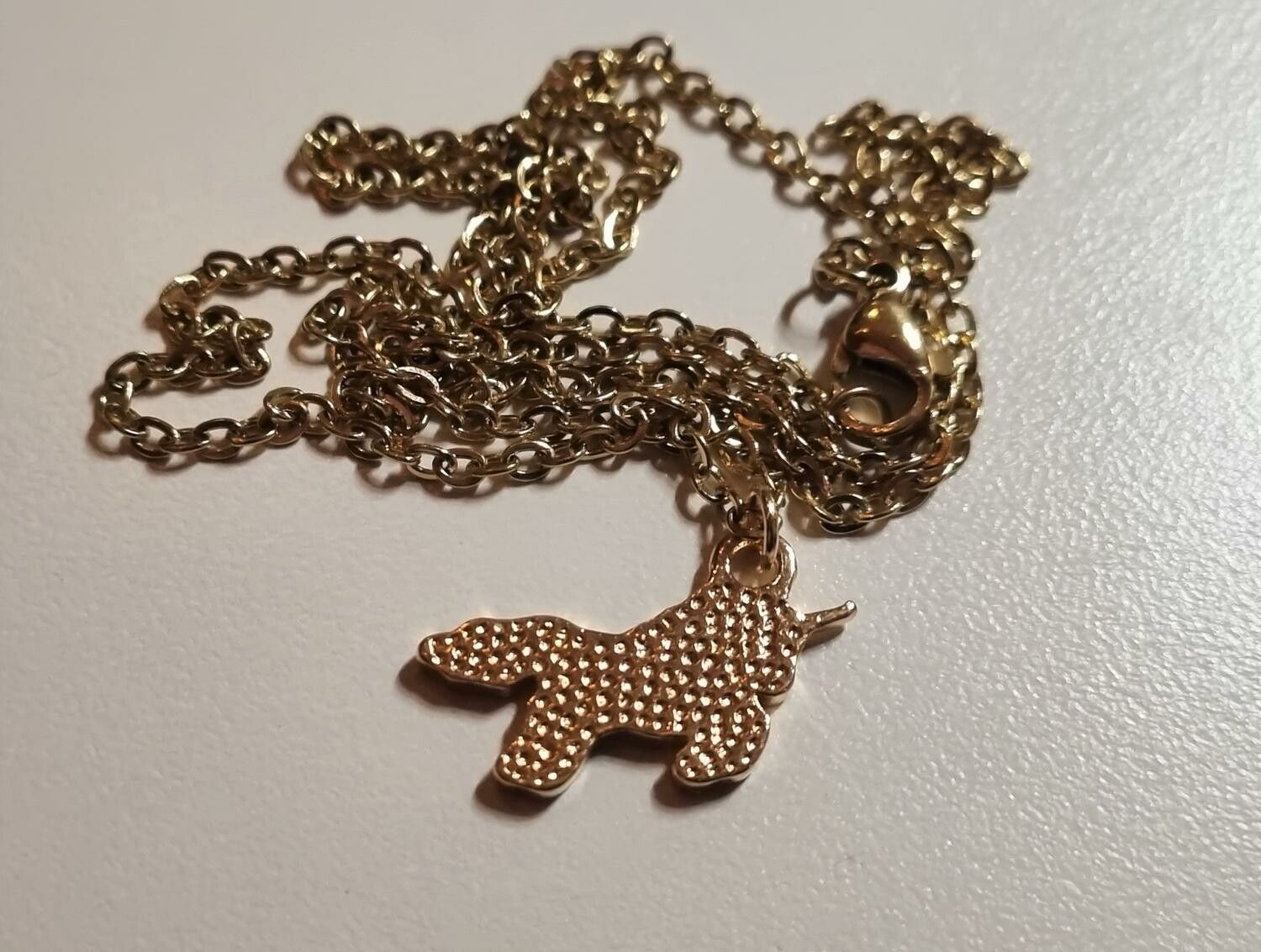 Guldfärgat halsband med en lila enhörning, berlock / charm