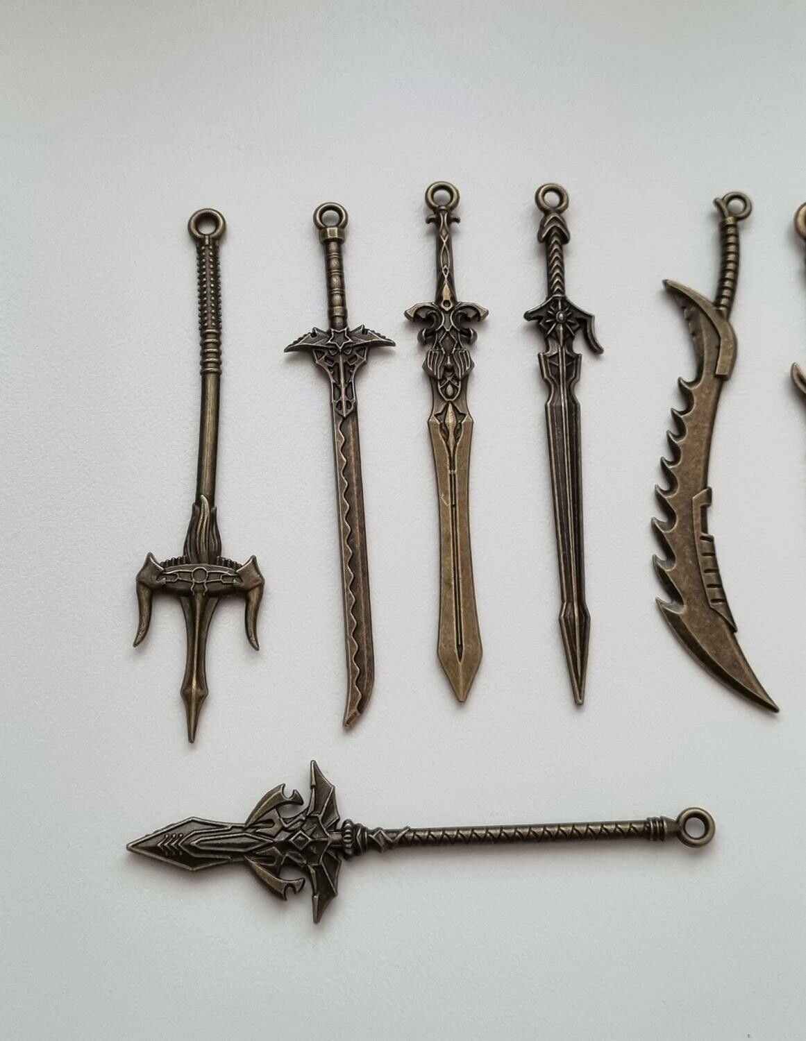 10 st berlocker - Miniatyrvapen, minisvärd, treuddar med mera. Fina miniatyrer
