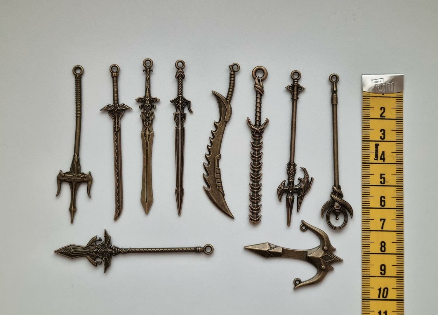 10 st berlocker - Miniatyrvapen, minisvärd, treuddar med mera. Fina miniatyrer