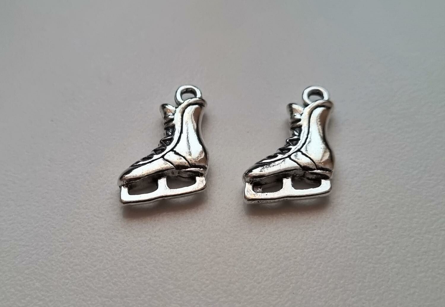 2 st små skridskor, miniatyrer / berlocker / charms (silverfärgade)