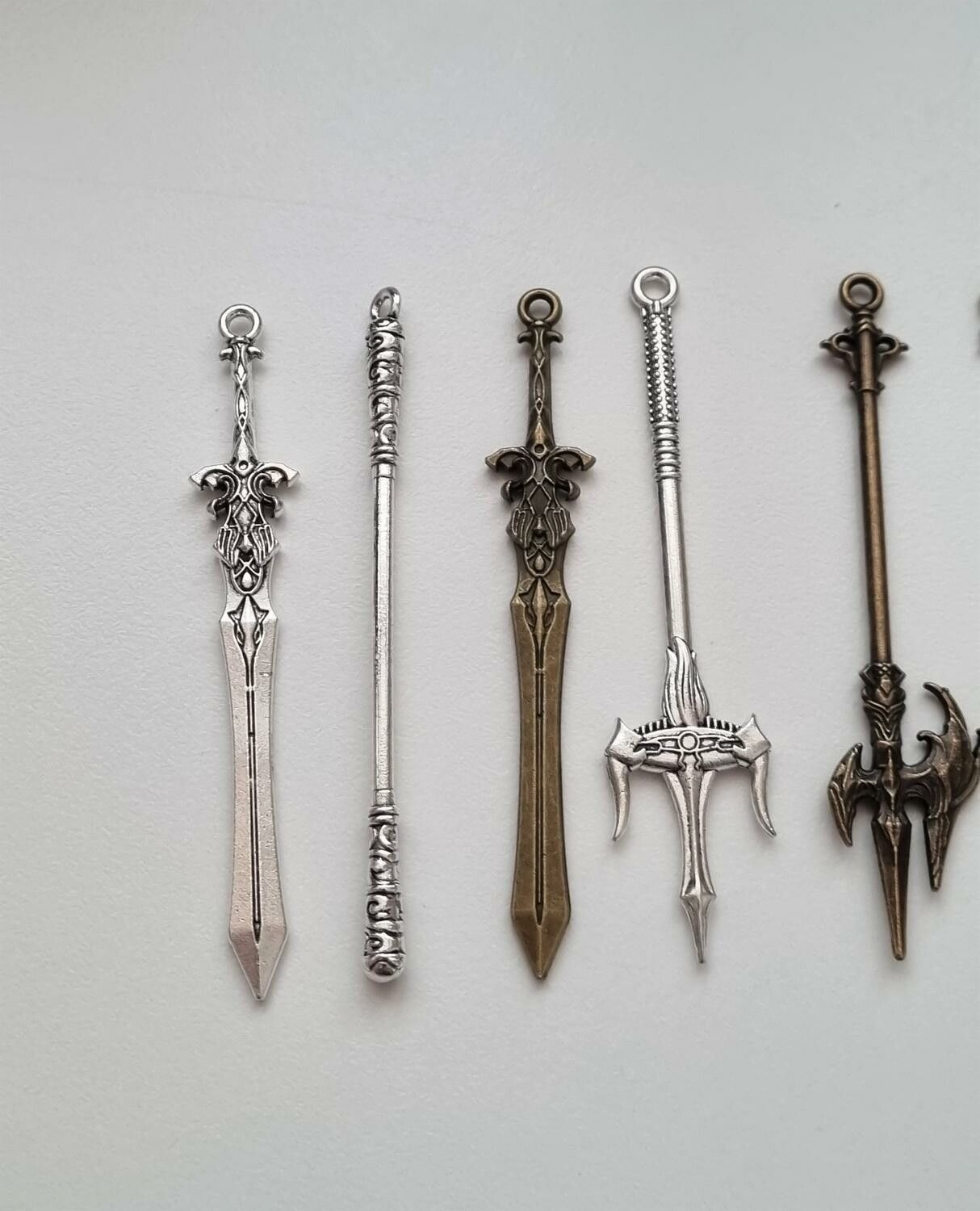 9 st berlocker - Miniatyrvapen, minisvärd, treuddar med mera. Fina miniatyrer
