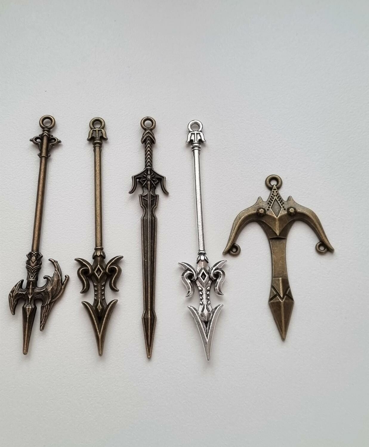 9 st berlocker - Miniatyrvapen, minisvärd, treuddar med mera. Fina miniatyrer